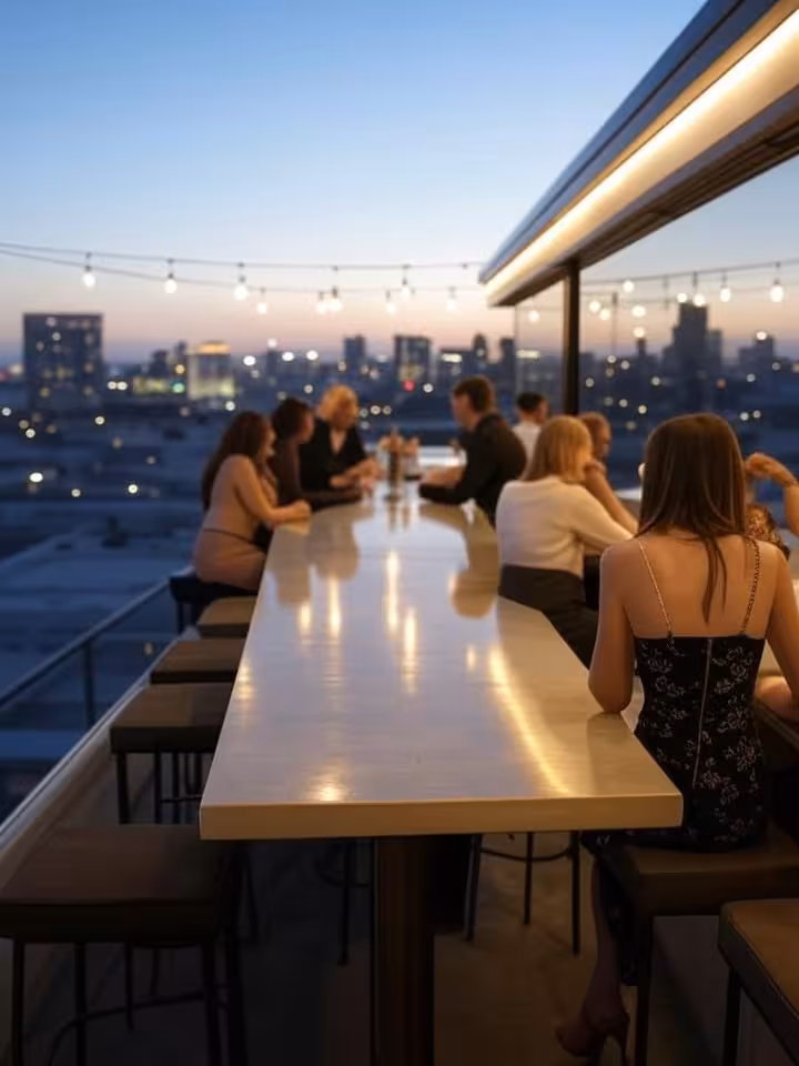 Sophisticated rooftop bar scene in downtown San Diego at twilight, city lights beginning to glow, el