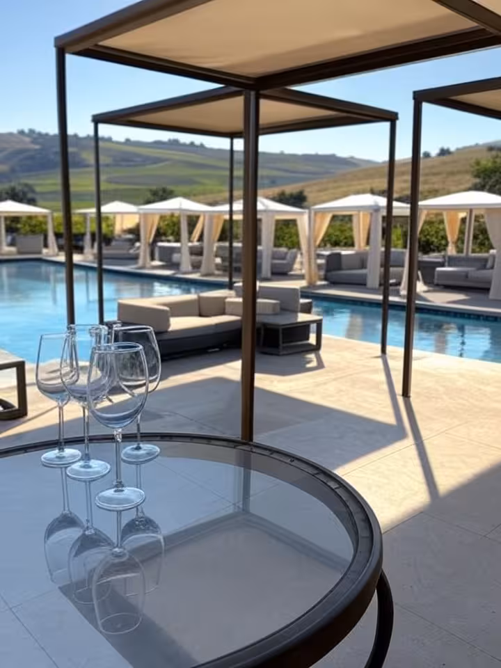 Resort-style pool cabanas at upscale winery, sunny day, wine glasses poolside, movie memorabilia vis