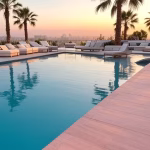 Luxurious modern rooftop pool deck at exclusive private club in West Hollywood, golden hour lighting
