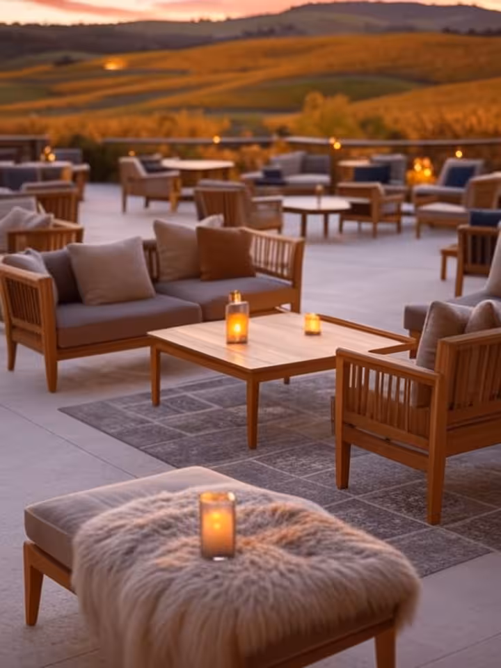 Luxury resort terrace overlooking Napa Valley vineyards at sunset, intimate seating area, autumn col